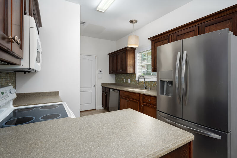 Kitchen with stainless refrigerator and solid surface counters